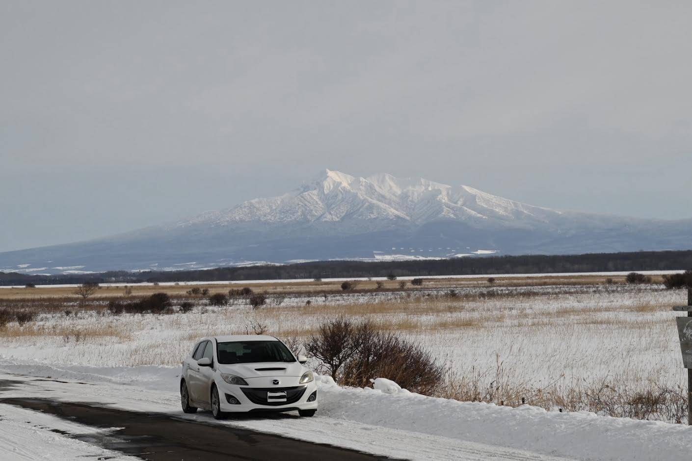 北海道の雪山を背に映えるマツダスピードアクセラ！！